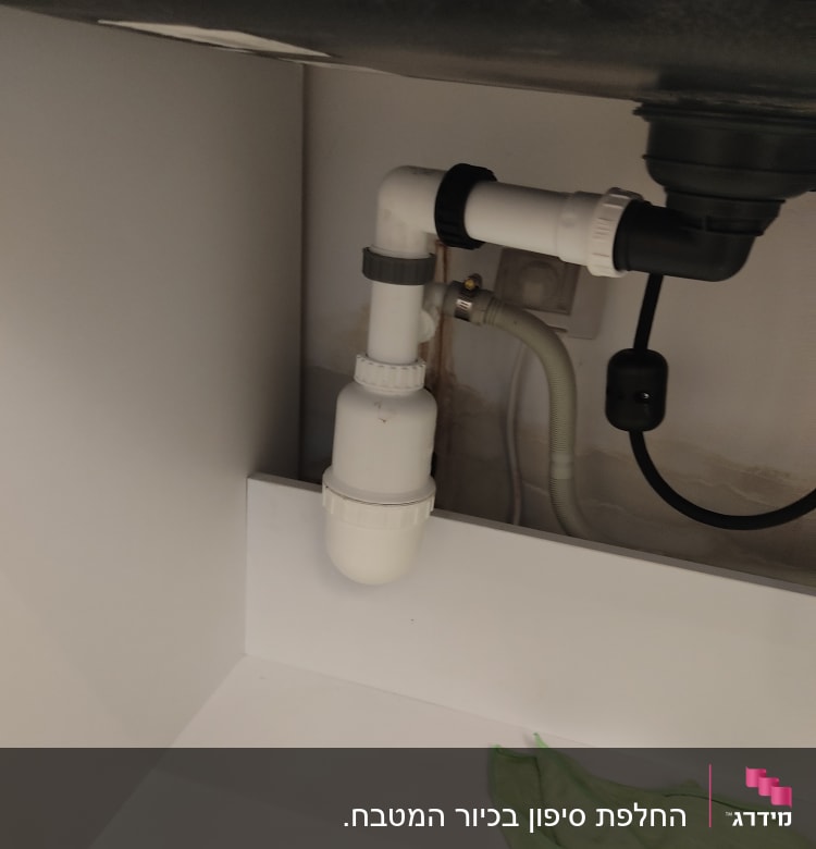 צנרת פלסטיק מתחת לכיור עם מחבר זוויתי